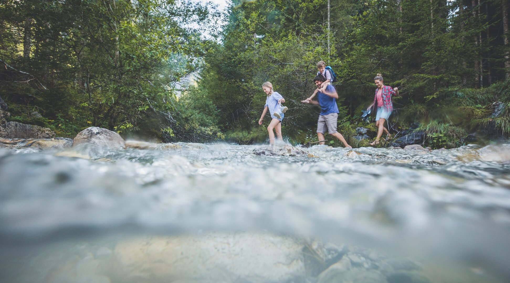 Wassererlebnisweg | © Tiroler Zugspitz Arena/C. Jorda Eine Familie wandert durch einen kleinen Bach | © Tiroler Zugspitz Arena/C. Jorda