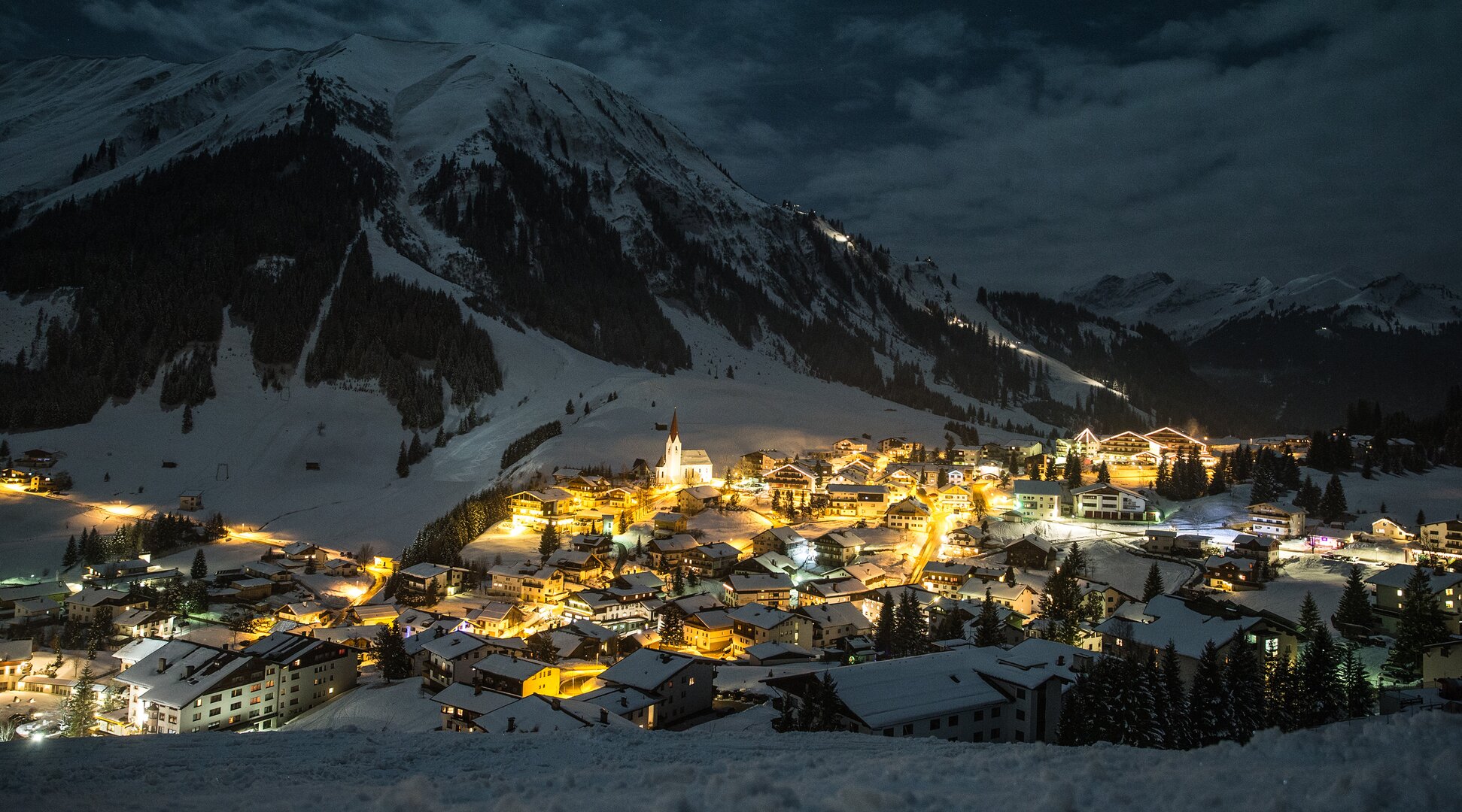 Winter sports in the evening | © Tiroler Zugspitz Arena/C. Jorda An illuminated and snow-covered mountain village | © Tiroler Zugspitz Arena/C. Jorda